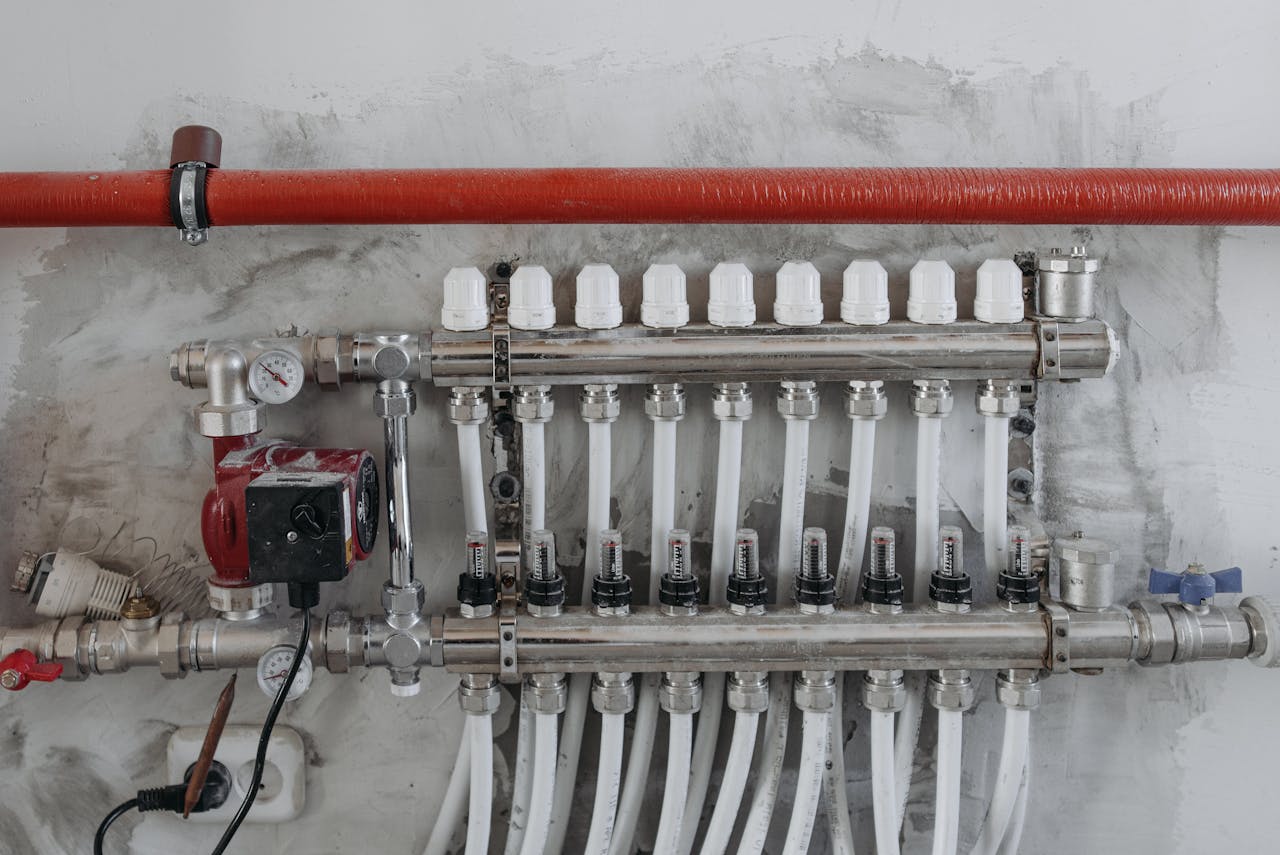 who-we-are A close-up view of an industrial manifold with pressure gauges and connected steel pipes.