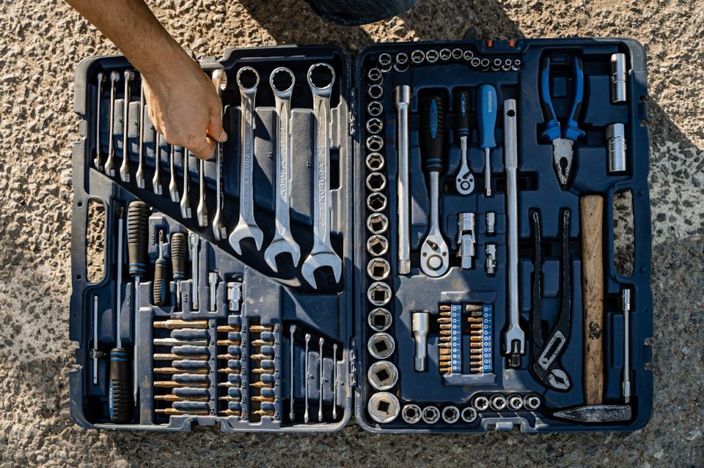 pexels photo 9607049 Open toolkit with assorted hand tools, including wrenches and pliers, captured outdoors.